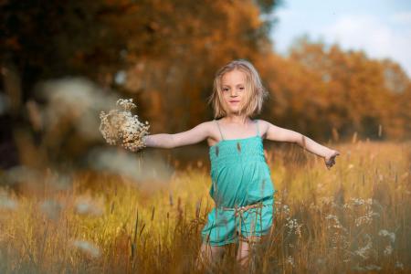 mädchen mit blumen im feld familienshooting